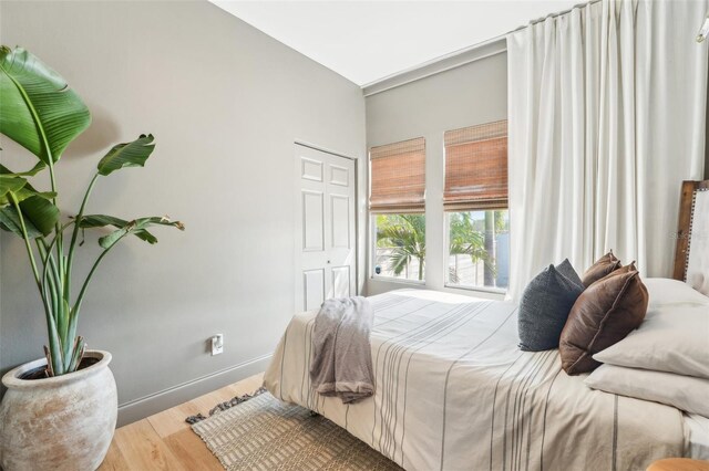 bedroom with baseboards and wood finished floors