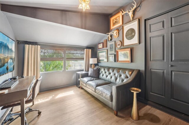 home office featuring lofted ceiling and light wood-style flooring