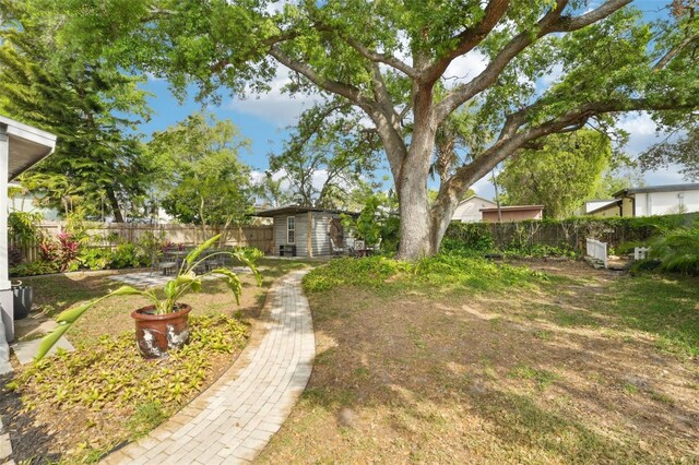 view of yard with a fenced backyard and an outbuilding