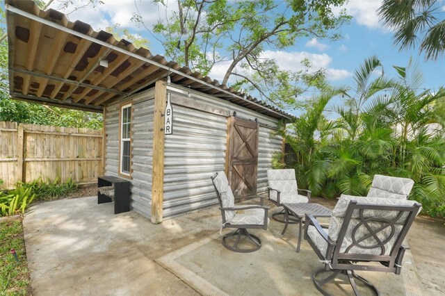 view of patio featuring an outbuilding and fence