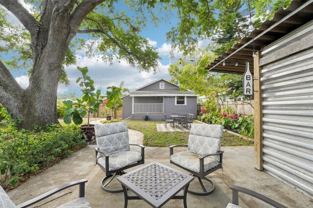 view of patio featuring fence, outdoor dining area, and an outdoor structure