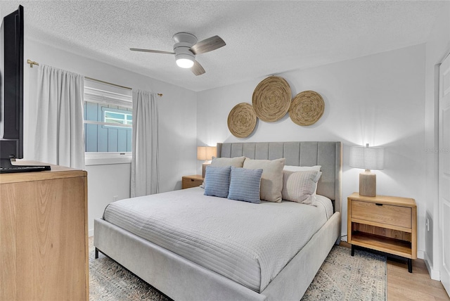 2116/2114 1st St, Indian Rocks Beach, FL 33785 - bedroom with light wood-style flooring, a textured ceiling, and ceiling fan