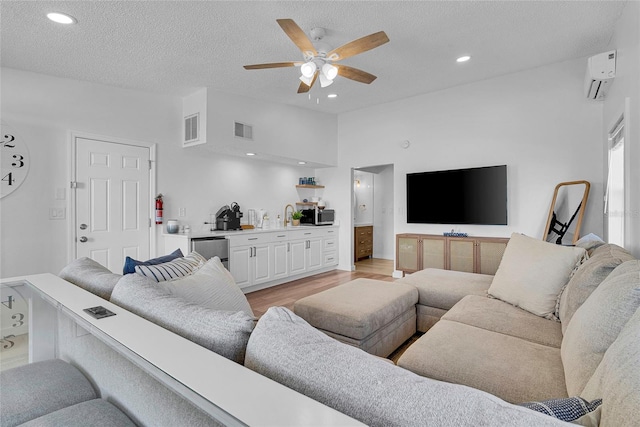 2116/2114 1st St, Indian Rocks Beach, FL 33785 - living area featuring light wood-style flooring, ceiling fan, a wall unit AC, recessed lighting, and a textured ceiling