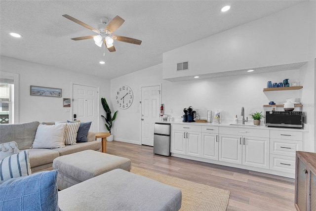 2116/2114 1st St, Indian Rocks Beach, FL 33785 - living area with light wood-type flooring, a ceiling fan, recessed lighting, lofted ceiling, and a textured ceiling