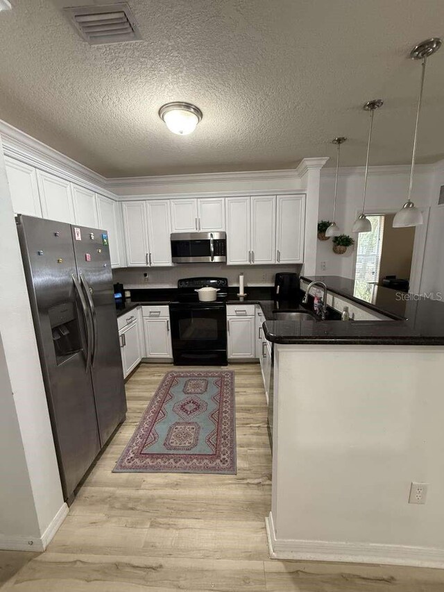 1185 SW 9th Rd Unit 107, Gainesville, FL 32601 - kitchen with visible vents, a peninsula, dark countertops, appliances with stainless steel finishes, and white cabinetry