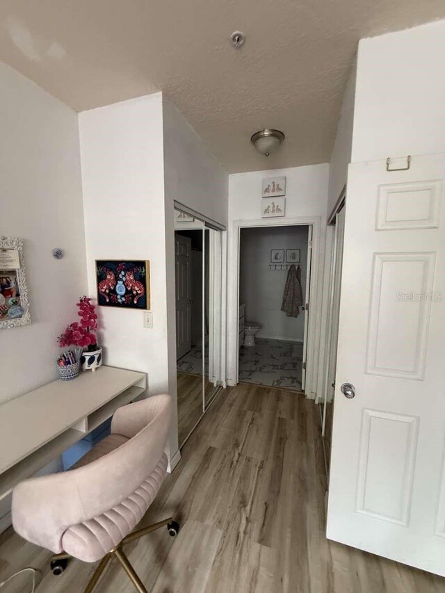 1185 SW 9th Rd Unit 107, Gainesville, FL 32601 - corridor with light wood-style flooring and a textured ceiling