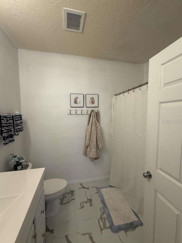 1185 SW 9th Rd Unit 107, Gainesville, FL 32601 - bathroom with toilet, vanity, marble finish floor, baseboards, and visible vents