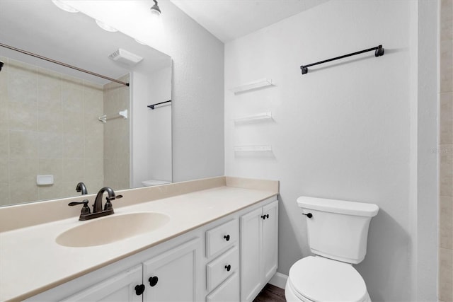 full bathroom featuring toilet, vanity, visible vents, and walk in shower