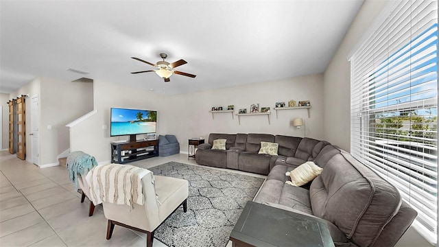 living room featuring visible vents, a ceiling fan, baseboards, and light tile patterned floors