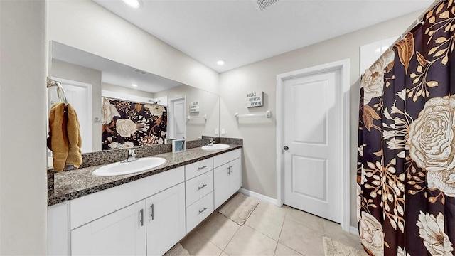 full bath featuring baseboards, tile patterned flooring, a sink, and double vanity