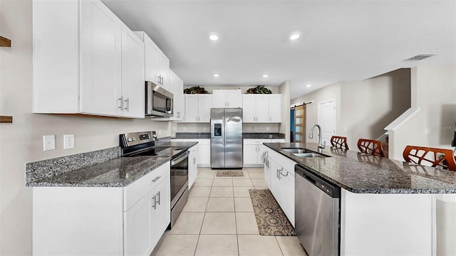 kitchen featuring light tile patterned floors, white cabinetry, stainless steel appliances, and a sink