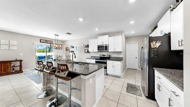 kitchen featuring light tile patterned floors, white cabinetry, stainless steel appliances, and a sink