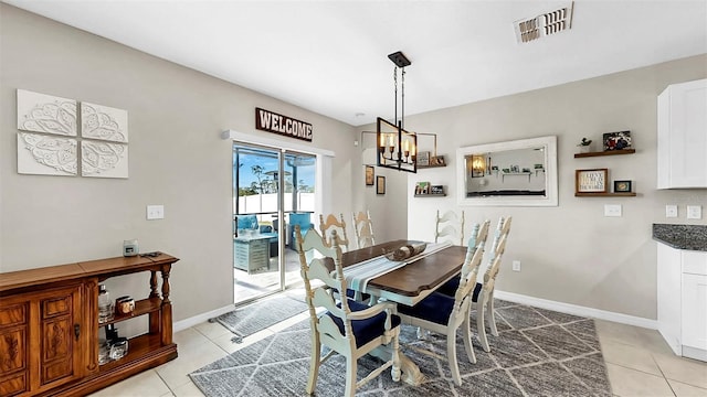 dining space with visible vents, baseboards, a notable chandelier, and light tile patterned floors