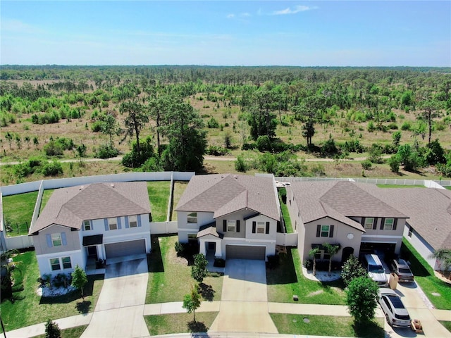 drone / aerial view featuring a forest view and a residential view