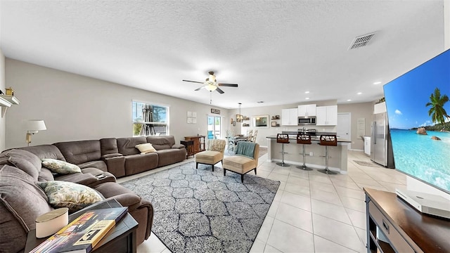 living room featuring a ceiling fan, light tile patterned flooring, baseboards, visible vents, and recessed lighting