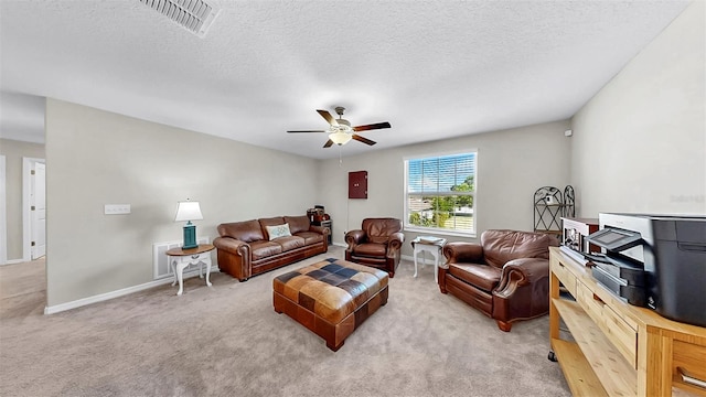 carpeted living room with a textured ceiling, visible vents, a ceiling fan, and baseboards
