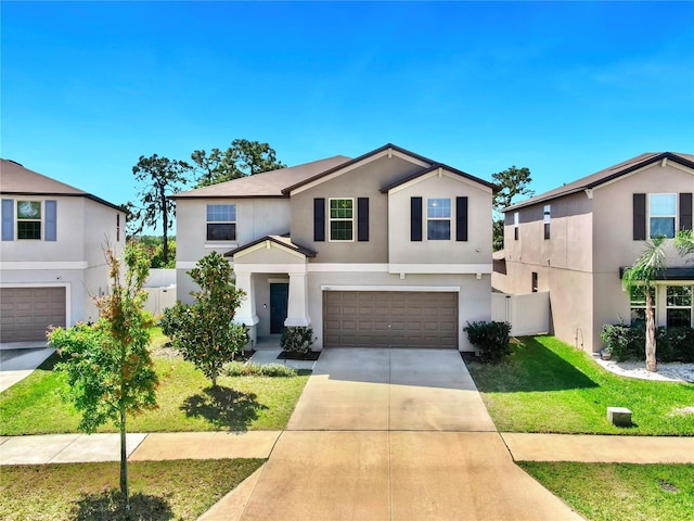 traditional-style house featuring fence, a front lawn, stucco siding, an attached garage, and driveway