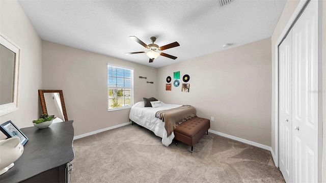 bedroom with a closet, baseboards, and light carpet