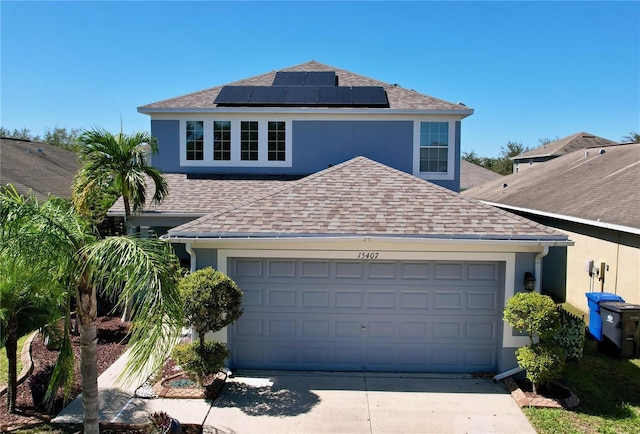 view of front of home with stucco siding, a shingled roof, and solar panels