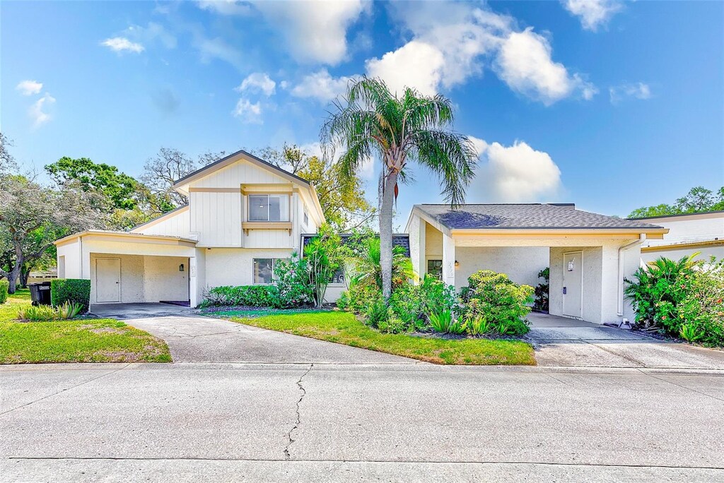 2581 Forest Run Ct, Clearwater, FL 33761 - view of front of property with driveway, an attached carport, a front yard, and stucco siding