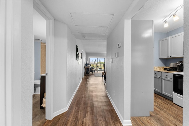 1901 Oyster Catcher Ln Unit 823, Clearwater, FL 33762 - hallway with track lighting, baseboards, attic access, dark wood-type flooring, and a textured wall
