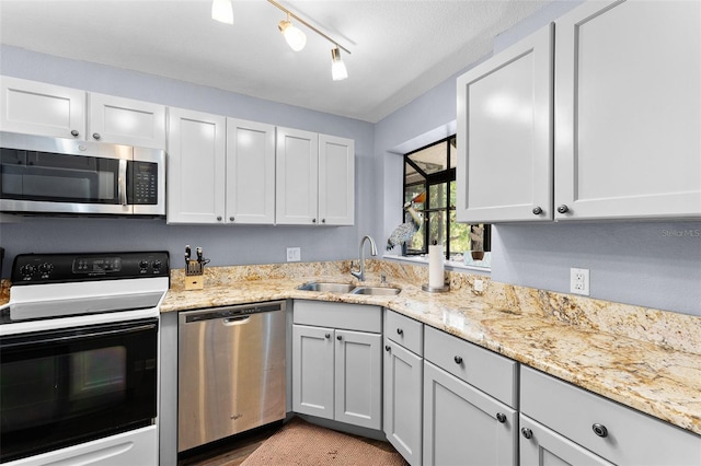1901 Oyster Catcher Ln Unit 823, Clearwater, FL 33762 - kitchen with light stone counters, track lighting, a sink, and stainless steel appliances