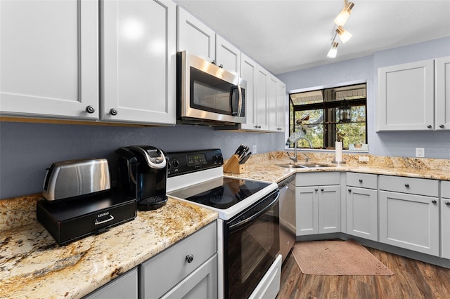 1901 Oyster Catcher Ln Unit 823, Clearwater, FL 33762 - kitchen featuring dark wood-style floors, a sink, appliances with stainless steel finishes, and light stone counters