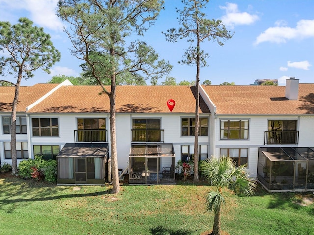 1901 Oyster Catcher Ln Unit 823, Clearwater, FL 33762 - rear view of property with a shingled roof, an outdoor structure, and a yard