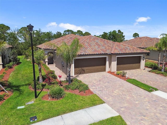 12379 Amica Loop, Venice, FL 34293 - mediterranean / spanish home featuring stucco siding, an attached garage, a front yard, driveway, and a tile roof