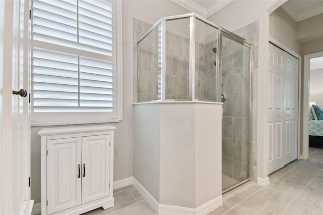 12379 Amica Loop, Venice, FL 34293 - ensuite bathroom featuring a stall shower, tile patterned flooring, ornamental molding, and baseboards