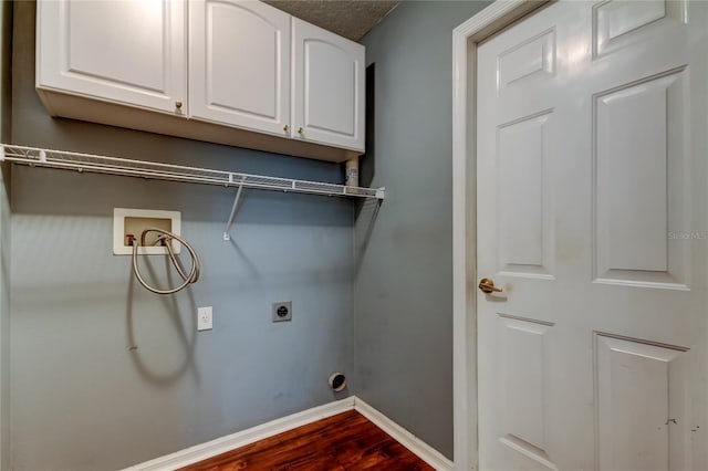 clothes washing area featuring washer hookup, electric dryer hookup, baseboards, cabinet space, and dark wood-style flooring
