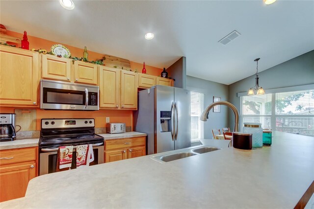 kitchen featuring light countertops, visible vents, appliances with stainless steel finishes, lofted ceiling, and a sink
