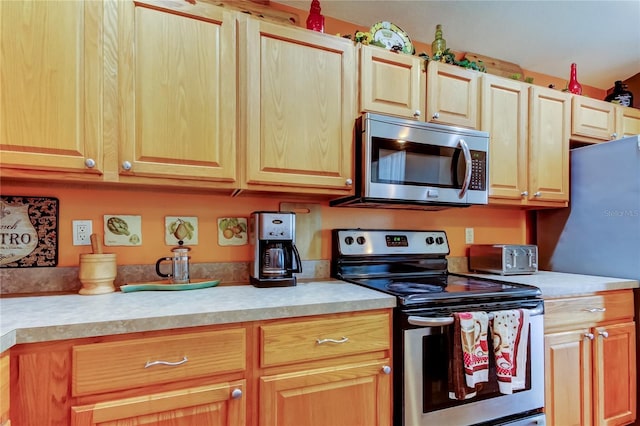 kitchen featuring light countertops, light brown cabinetry, and stainless steel appliances