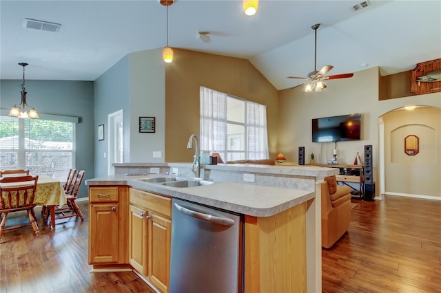 kitchen featuring vaulted ceiling, a sink, wood finished floors, dishwasher, and visible vents