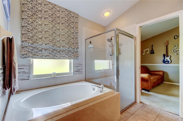 full bathroom with tile patterned flooring, vaulted ceiling, a garden tub, and a shower stall