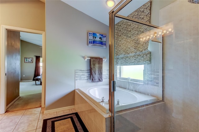 full bath featuring lofted ceiling, tile patterned flooring, and a garden tub