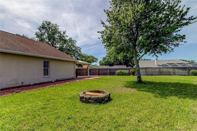 view of yard with an outdoor fire pit and fence