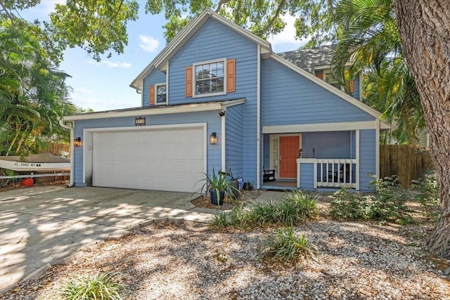 traditional-style home with driveway, fence, and an attached garage