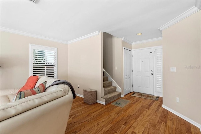 living room with baseboards, stairs, ornamental molding, and wood finished floors