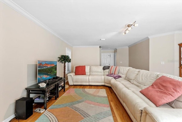 living room with baseboards, wood finished floors, and crown molding