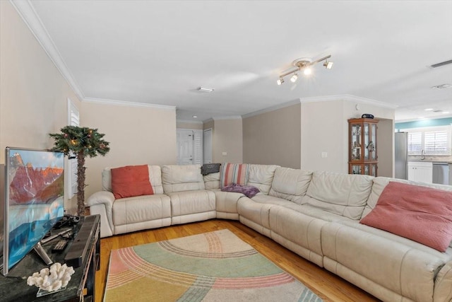 living room with light wood-type flooring, visible vents, and ornamental molding