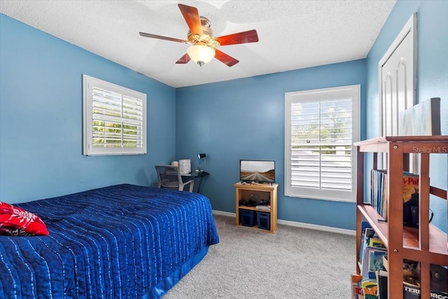 carpeted bedroom with baseboards, a textured ceiling, and ceiling fan