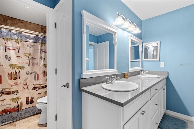 bathroom with double vanity, toilet, baseboards, and a sink