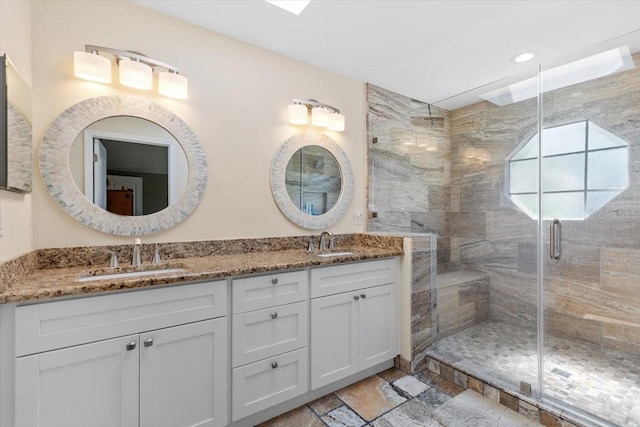 full bath with a stall shower, double vanity, stone tile flooring, and a sink