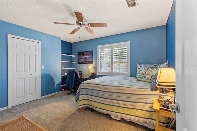 carpeted bedroom with a textured ceiling, visible vents, a closet, and a ceiling fan