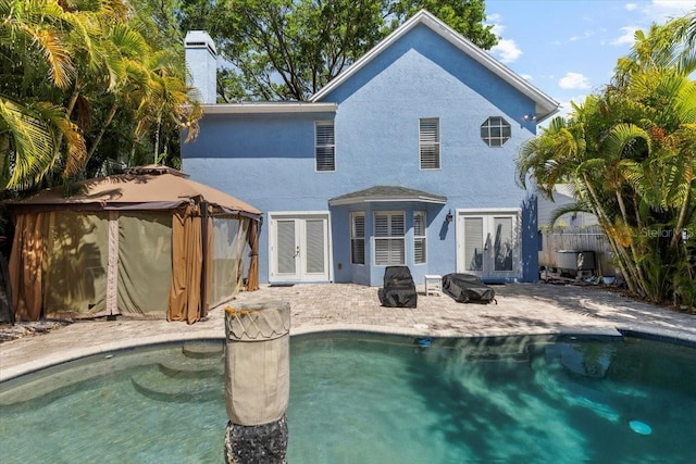 back of house with stucco siding, a gazebo, french doors, and a patio area