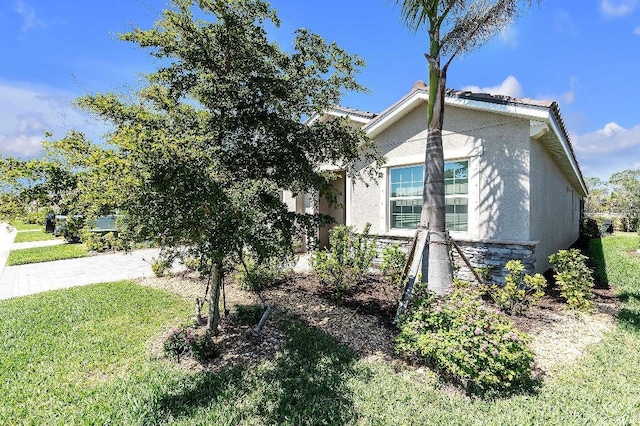 20647 Ovid Ln, Venice, FL 34293 - view of home's exterior featuring stone siding, stucco siding, and a lawn