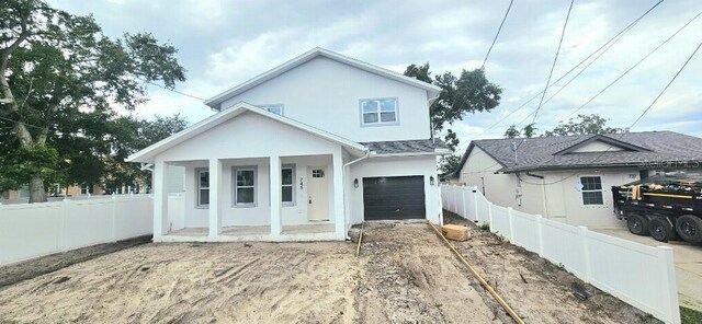 745 31st Ave N, Saint Petersburg, FL 33704 - view of front facade with a porch, an attached garage, stucco siding, and driveway