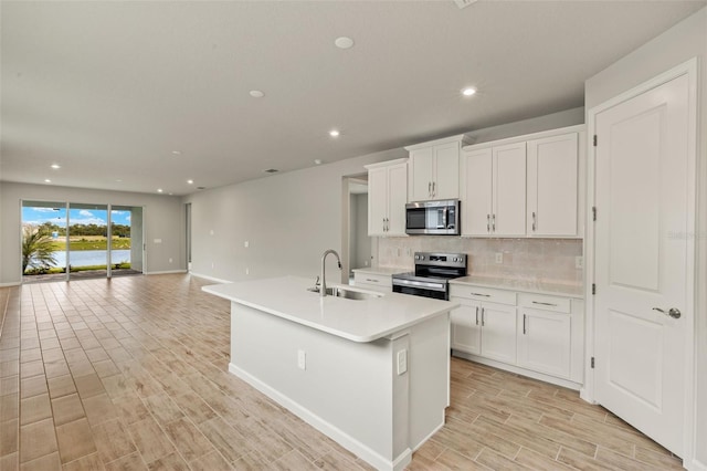 17800 Solstice Ave, Venice, FL 34293 - kitchen with tasteful backsplash, light wood-type flooring, white cabinets, appliances with stainless steel finishes, and a sink