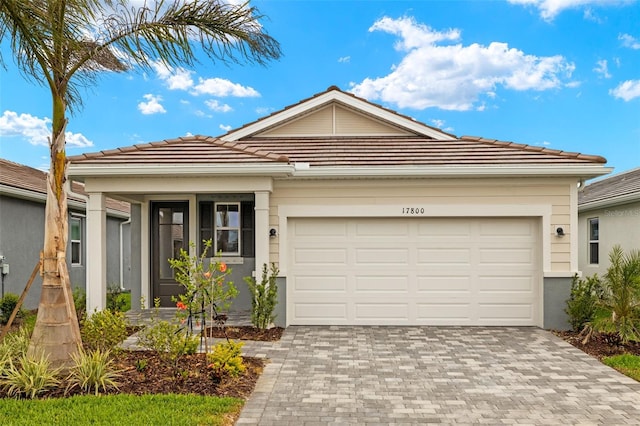 17800 Solstice Ave, Venice, FL 34293 - view of front of property featuring a garage, stucco siding, decorative driveway, and a tile roof